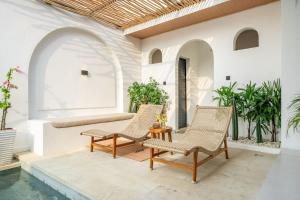 d'une terrasse avec des chaises et une table à côté de la piscine. dans l'établissement Modern 2BR Villa in Bingin V2, à Uluwatu