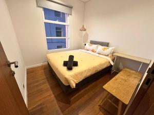 a small bedroom with a bed with a cross on it at Sky Suites Home Stay AT kLCC AREA in Kuala Lumpur