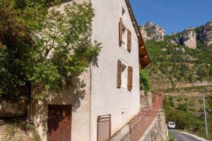 a building with a door on the side of a mountain at La maisonnette à la caze in Saint-Pierre-des-Tripiers