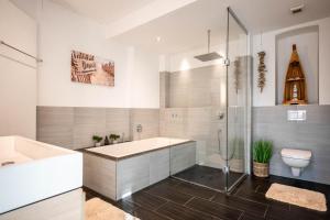 ビーレフェルトにあるGroße, zentrale Wohnung in Bielefeldの浴槽、洗面台、トイレを備えたバスルーム +11枚の写真