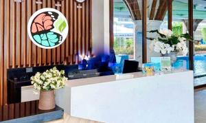 a lobby with a counter with flowers on it at RedDoorz Plus at Nick Hotel Guimba in Guimba