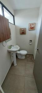 un baño con inodoro y lavabo en Peach Haven 143, en San Juan Opico