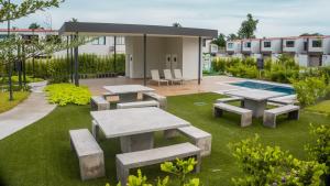 Un patio con mesas de picnic y una piscina. en Peach Haven 143, en San Juan Opico