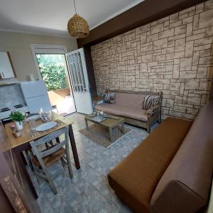 a living room with a couch and a brick wall at The Mastiha Spot 4 in Chios