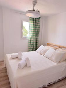 a bedroom with a large white bed with towels on it at Sibs Sanlucar - casita playa - coqueto vistas in Sanlúcar de Barrameda