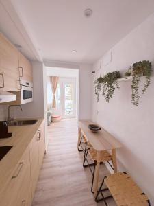 a kitchen with a wooden table with plants on the wall at Sibs Sanlucar - casita playa - coqueto vistas in Sanlúcar de Barrameda