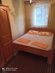 a bedroom with a bed with two pillows and a window at Villa Zorka in Sutomore
