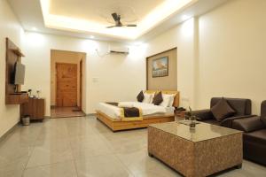 a living room with a bed and a couch at Kudrat Resort-Jim Corbett in Kota Bāgh