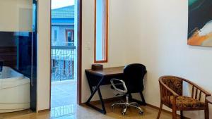 a desk and a chair in a room with a window at RedDoorz Plus at Nick Hotel Guimba in Guimba
