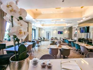 a restaurant with tables and chairs and flowers at Boutique Hotel Balș in Balş