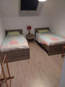 a bedroom with two beds and a tv on the wall at Cenina in Saint-Pair-sur-Mer