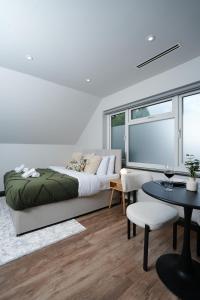 New SouthgateにあるModern Arnos Grove Studio, Air Conditioningのベッドとテーブルと椅子のある寝室