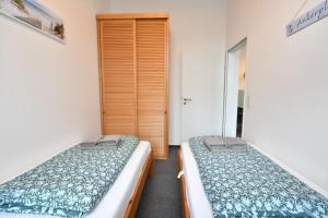 two twin beds in a room with a closet at Nordseehus, Whg 5 in Borkum