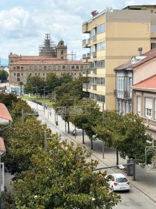 a city street with trees and buildings and a car at Cardenal Centro in Monforte de Lemos