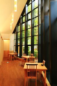 a room with tables and chairs and large windows at Iruka Onsen Hotel Seiryuusou in Kumano