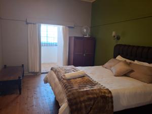 a bedroom with a large bed in a room at Ruitersrust in Fauresmith