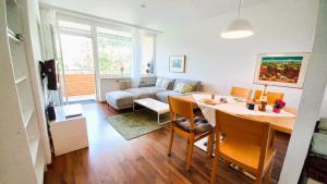 a living room with a table and a couch at SIMON Haus KMB Seeappartement am Ossiacher See, Hallenbad, Skiarena Gerlitzen in Tschöran