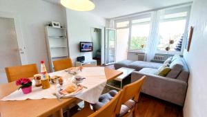 a living room with a table and a couch at SIMON Haus KMB Seeappartement am Ossiacher See, Hallenbad, Skiarena Gerlitzen in Tschöran