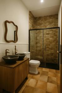a bathroom with two sinks and a toilet and a shower at Edennia I El Cielo en La Tierra in Mora +40 photos