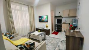 a living room with a couch and a kitchen at Kiambu road Green Zone Macedonia in Kiambu