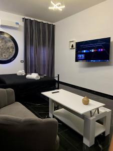 a room with a couch and a table and a tv at Syràkousai Prestige in Syracuse +23 photos