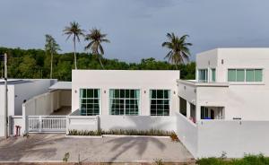 a white house with palm trees in the background at White house poolvilla บ้านพักพูลวิลล่า ชุมพร Pp2 in Chumphon