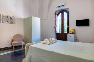 a bedroom with a bed with a chair and a window at Gma Home Primo Piano in Pulsano