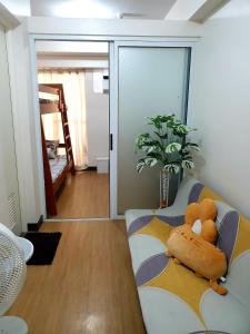 a teddy bear sitting on a couch in a living room at Cuddle & Cradle Staycation at The Celandine in Manila