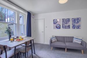 ein Wohnzimmer mit Tisch und Couch in der Unterkunft Modern Serviced Apartments Steps From Gloucester Quays in Gloucester