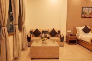 een woonkamer met een bank en een bed bij Kudrat Resort-Jim Corbett in Kota Bāgh +15 foto's