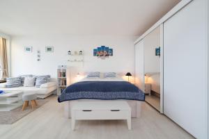 a white bedroom with a bed and a couch at Panoramic App B08-6 in Sierksdorf +20 photos