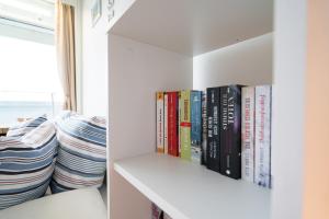 a book shelf with books on it next to a window at Panoramic App B08-6 in Sierksdorf