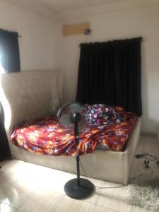 a bedroom with a bed with a fan next to a window at Magnificent Cozy Apartment in Akowonjo