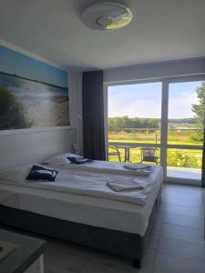 ein Schlafzimmer mit einem Bett und einem großen Fenster in der Unterkunft Sea Power Horyzont in Jastrzębia Góra