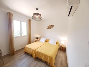 ein Schlafzimmer mit einem Bett mit einer gelben Decke in der Unterkunft Appartement Candella 3 chambres in Galeria + 74 Fotos
