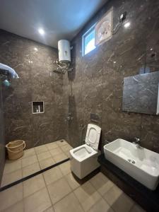 a bathroom with a toilet and a sink at AuroBESHA in Puducherry Airpoert +16 photos