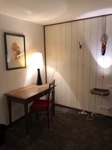 a room with a desk with a lamp and a chair at La Gentilhommière - Chambre avec sauna et jaccuzzi in Saint-Roch