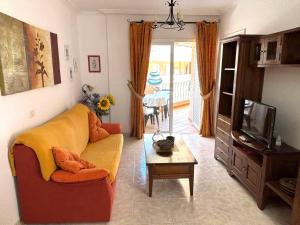 a living room with a couch and a tv at Veliero en Costa Sol M13 in Costa Del Silencio
