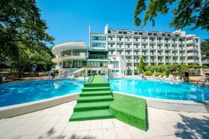 a swimming pool with a hotel in the background at Hotel Zdravets in Varna City