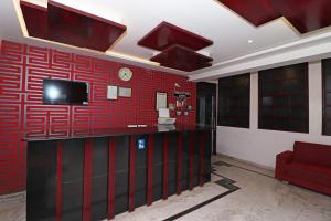 a room with a red wall with a tv on it at Hotel O D' Seasons Agra Cantt Railway Station in Tājganj +20 photos