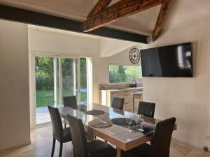 a dining room with a table and chairs and a clock at Le Moulin in Aix-en-Provence