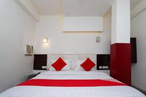 a bedroom with a large bed with red pillows at Hotel O D' Seasons Agra Cantt Railway Station in Tājganj