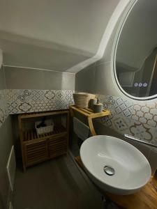 a bathroom with a white sink and a mirror at La Casa della Pizzica in Ostuni +4 photos
