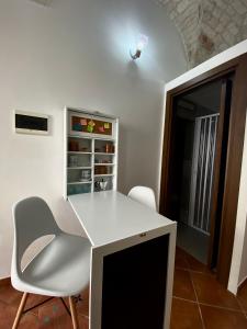 a white desk and a chair in a room at La Casa della Pizzica in Ostuni