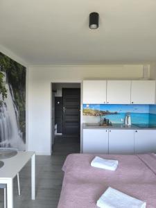 eine weiße Küche mit einem Bett und einem Tisch in der Unterkunft Sea Power Horyzont in Jastrzębia Góra