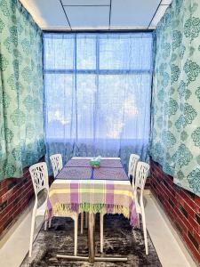 a dining room with a table and chairs and a window at Dusun Indah Cottage 2 in Bayan Lepas