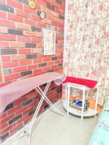a table and a chair next to a brick wall at Dusun Indah Cottage 2 in Bayan Lepas +6 photos