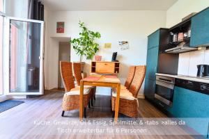 a kitchen with a table with a computer on it at Kinofilmwohnung mit großem Dachgarten im Gästehaus Graf-Schmelzer in Trittenheim +11 photos