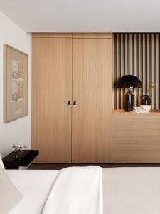 a bedroom with a bed and a wooden cabinet at Bob W Münchner Freiheit in Munich