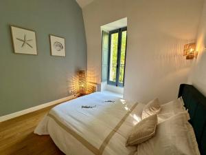 a bedroom with a large white bed with a window at Appartement T2 Méditerranéen in Narbonne